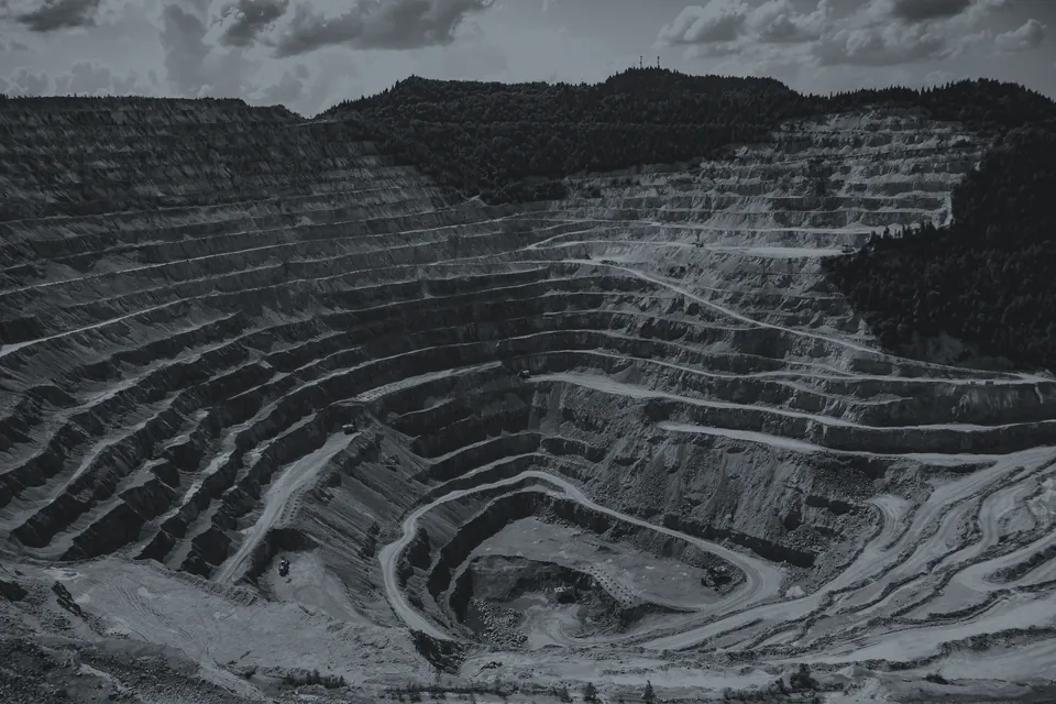 Open-pit mining operation: terraced benches and haul roads.